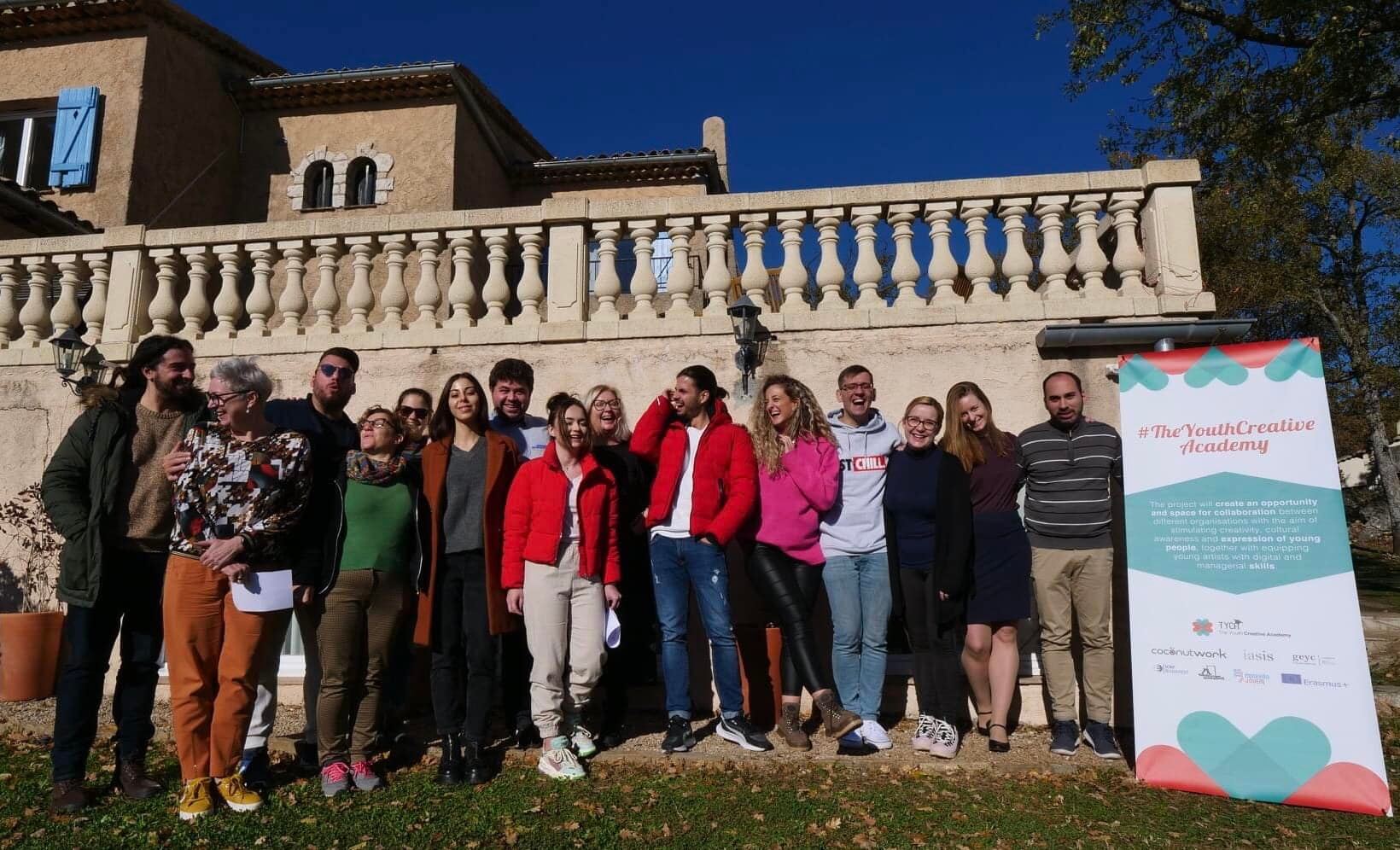 A group of people posing for a photo in front of a building Description automatically generated