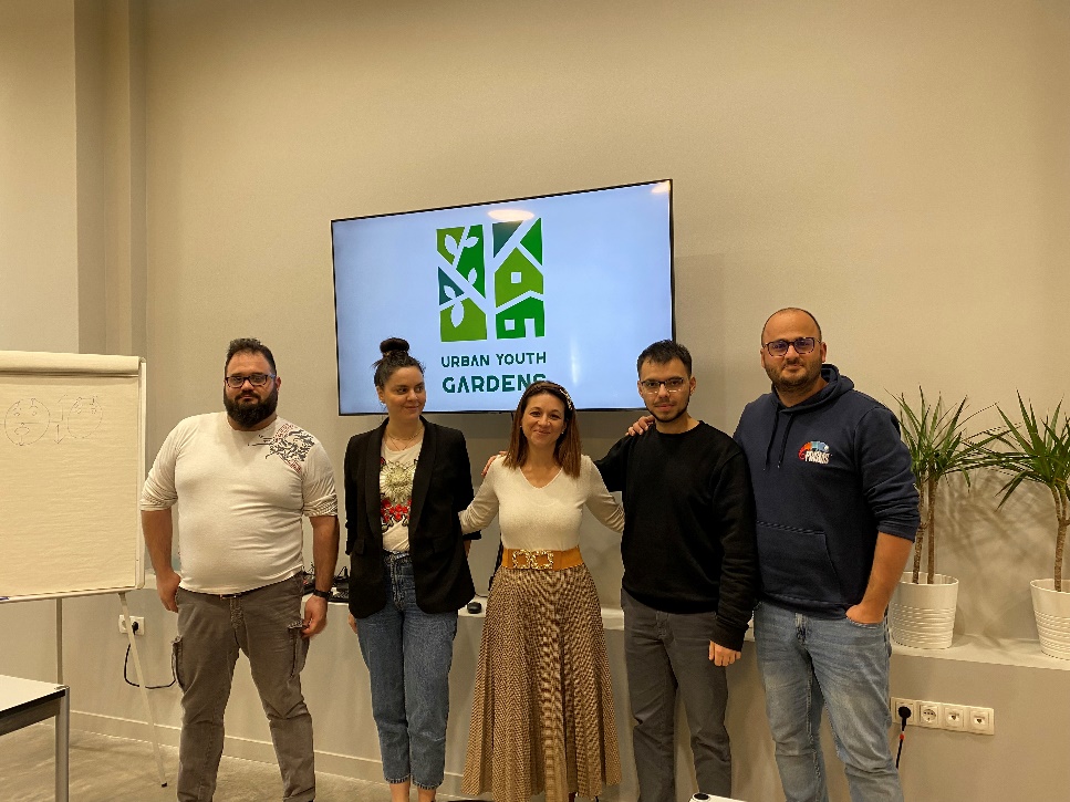 A group of people standing in front of a screen Description automatically generated